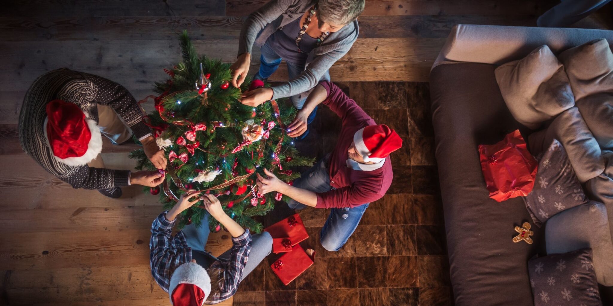Overhead shot of a family decorating a Christmas tree